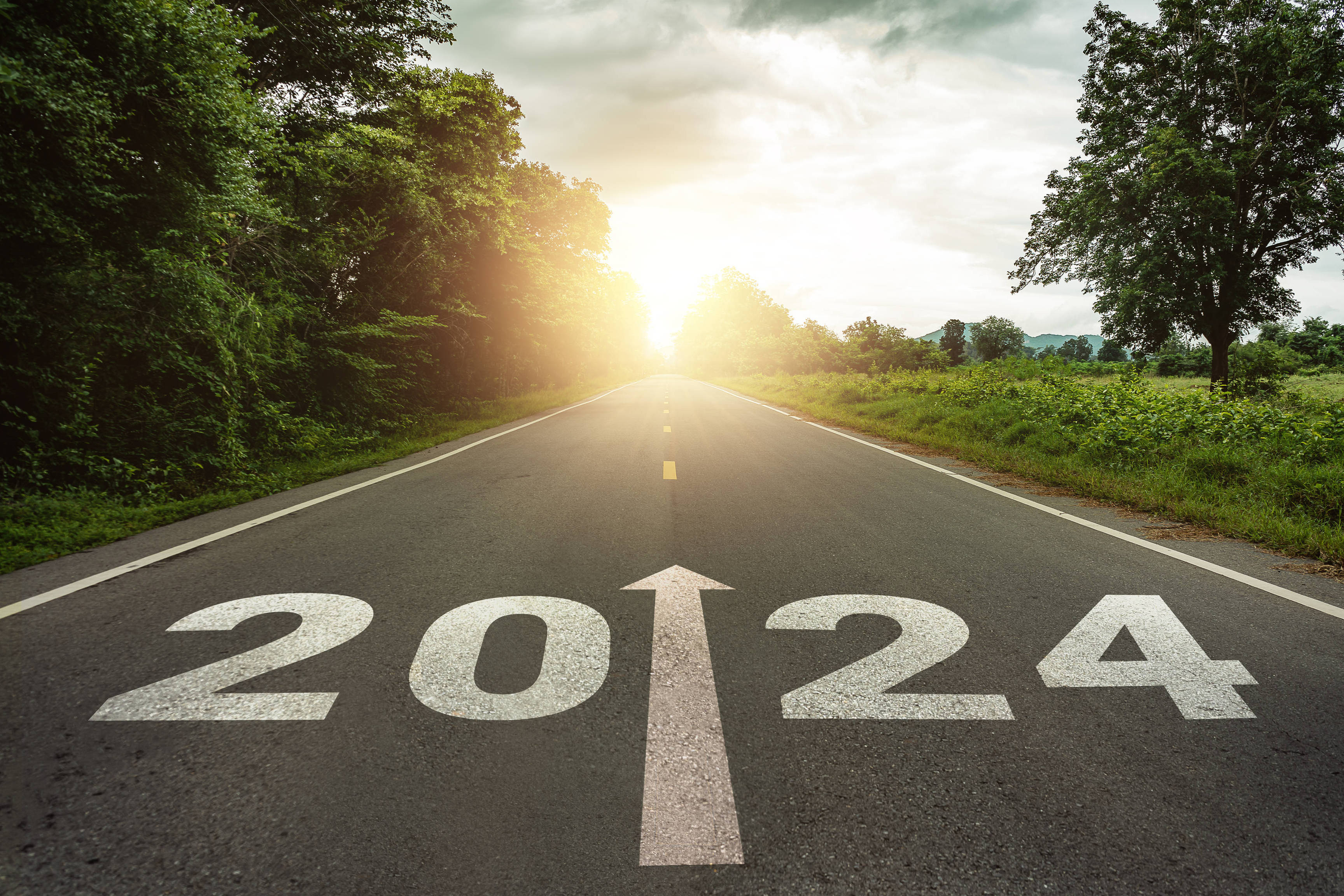 New year 2024 or straightforward concept. Text 2024 written on the road in the middle of asphalt road at sunset.Concept of planning and challenge, business strategy, opportunity ,hope, new life change